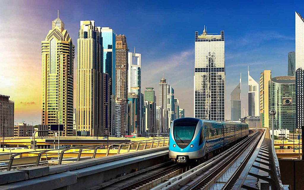 Commuters boarding Dubai Metro with skyline in background