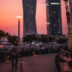 Winter tourists walking along Dubai waterfront with city skyline