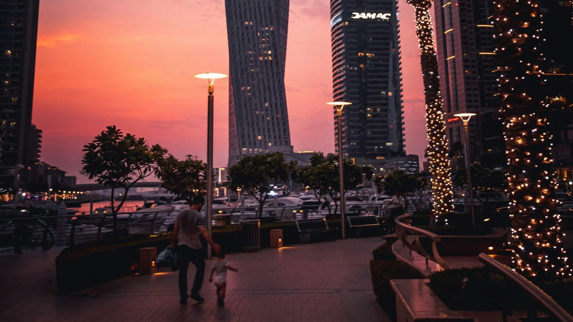 Winter tourists walking along Dubai waterfront with city skyline